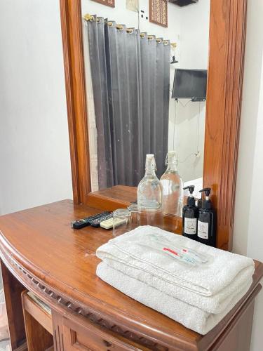 a wooden table with a mirror and a towel on it at Pi Home by Perwira Hub in Yogyakarta