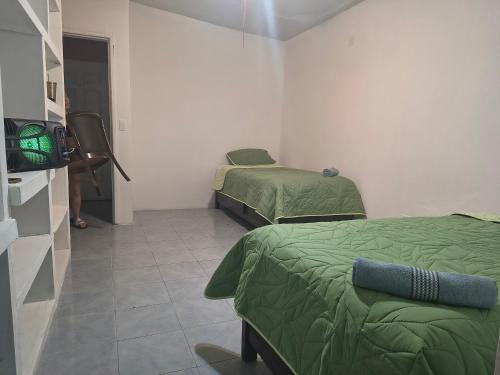 a room with two beds and a television in it at Cali Rooms BCS in La Paz
