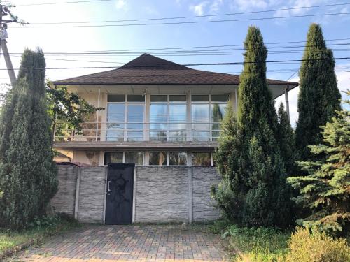 a house with a gate and two trees at Тownhouse99 in Petropavlovskaya Borshchagovka