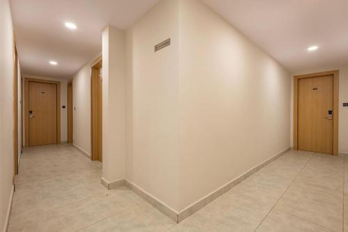 an empty hallway with doors and a tile floor at Harbourview Visakhapatnam RK Beach in Visakhapatnam