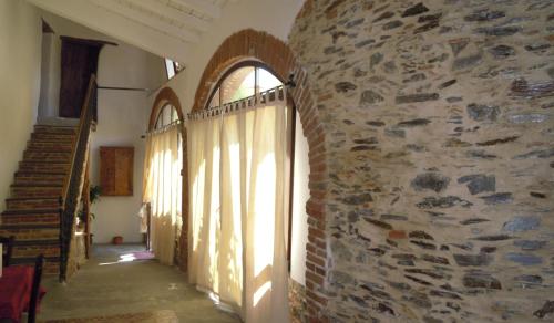 a hallway of a building with a stone wall at Il Portico Guesthouse in Muravera