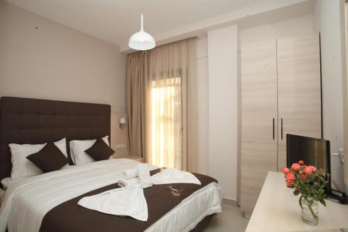 a bedroom with a large bed and a television at Kochili Seashell Apartments in Siviri