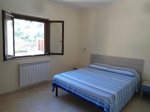 Habitación pequeña con cama y ventana en Appartamento Bilocale a 200 m dalla spiaggia en Vieste