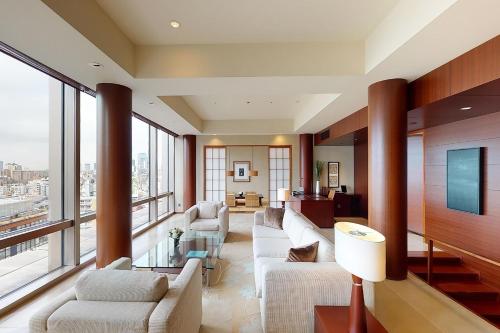 a living room with white furniture and large windows at Grand Hyatt Tokyo in Tokyo