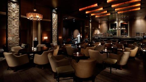 a restaurant with tables and chairs and a bar at Grand Hyatt Tokyo in Tokyo