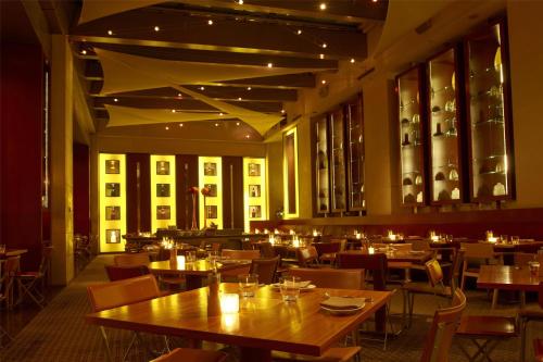 a restaurant with wooden tables and chairs and lights at Grand Hyatt Tokyo in Tokyo