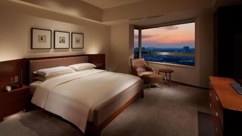 a bedroom with a bed and a desk and a window at Grand Hyatt Tokyo in Tokyo
