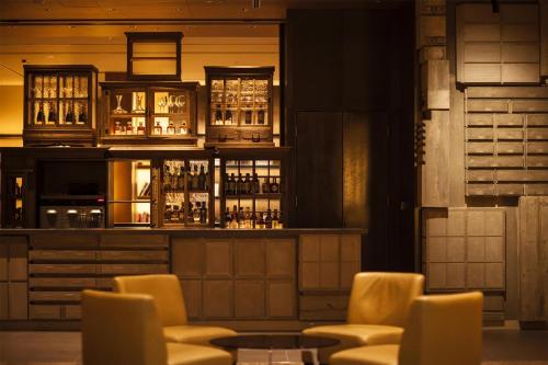 a bar with yellow chairs and liquor bottles at Grand Hyatt Tokyo in Tokyo