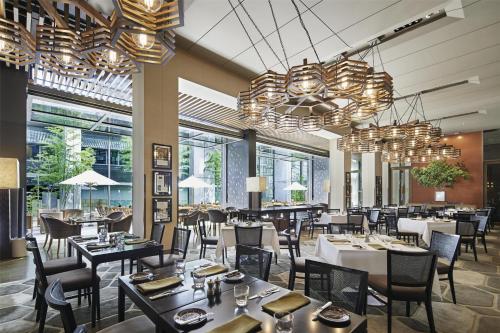 a restaurant with tables and chairs and chandeliers at Grand Hyatt Tokyo in Tokyo