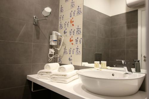 a bathroom with a sink, mirror, and bath tub at Hotel Riverside Alfama in Lisbon