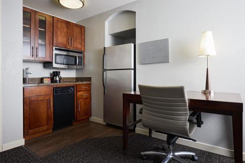 a kitchen with a desk and a refrigerator at Hyatt House Seattle/Redmond in Redmond