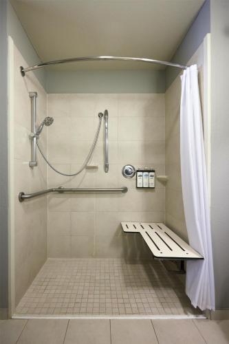 a shower with a bench in a bathroom at Hyatt House Seattle/Redmond in Redmond