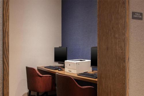 a desk with two computer monitors and a printer at Hyatt Place Detroit/Utica in Utica