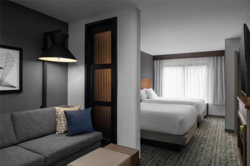 a hotel room with a bed and a couch at Hyatt Place Detroit/Utica in Utica