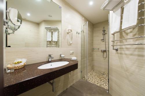 ein Bad mit einem Waschbecken und einer Dusche in der Unterkunft Bagration Hotel in Moskau