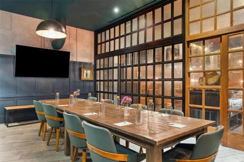 a conference room with a large wooden table and chairs at Motto by Hilton Washington DC City Center in Washington