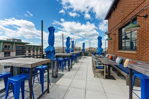 a row of tables and blue chairs on a patio at Motto by Hilton Washington DC City Center in Washington