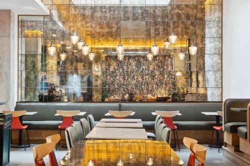a restaurant with tables and chairs and a wall mural at Motto by Hilton Washington DC City Center in Washington