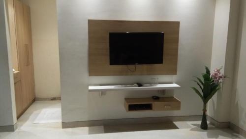 a living room with a tv on a wall at Amber Continental in Bareilly