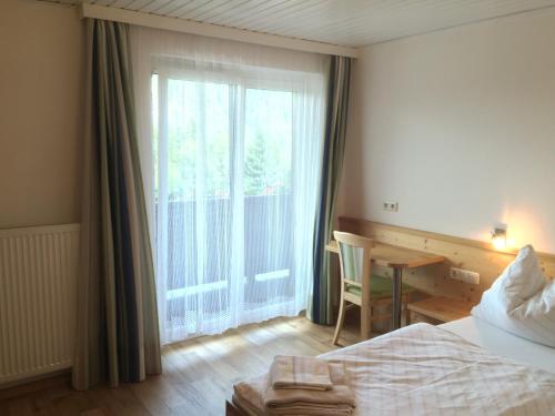 1 dormitorio con 1 cama y ventana con escritorio en Gasthof Tennenblick en Werfenweng