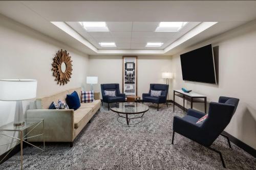 a living room with a couch and chairs and a tv at Stone Hill Norman, Trademark Collection by Wyndham in Norman