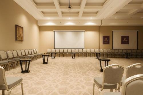 a conference room with chairs and a projection screen at Sunday Business Avenue Formerly Rand Hotel in Riyadh