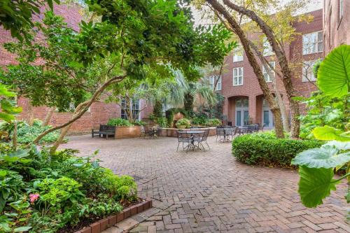 a brick courtyard with tables and chairs and trees at Church Street Inn Historic Charleston, Ascend Collection Hotel in Charleston