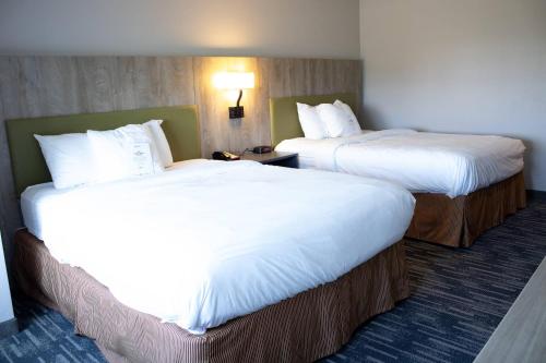 two beds in a hotel room with white sheets at Country Inn & Suites by Radisson, Carlisle, PA in Carlisle