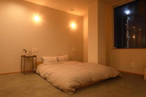 a large bed in a room with a window at BROOMSTAY Umeda west in Osaka