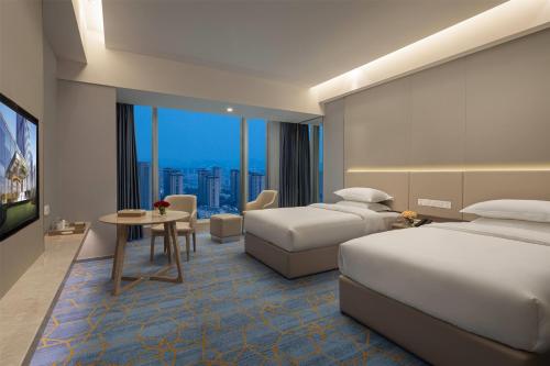 a hotel room with two beds and a table at Wyndham Shaoxing Keqiao in Shaoxing