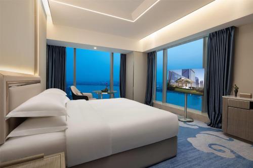a hotel room with a bed and a large window at Wyndham Shaoxing Keqiao in Shaoxing