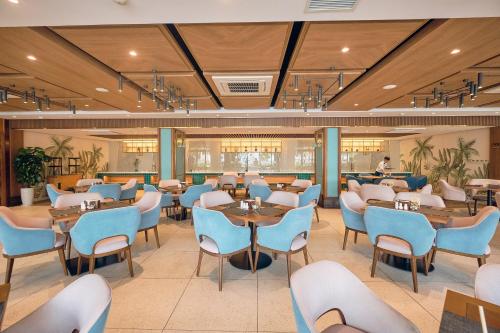 un ristorante con sedie blu e tavoli in una stanza di Ocean Sun Pool Villas Resort Cam Ranh a Cam Ranh
