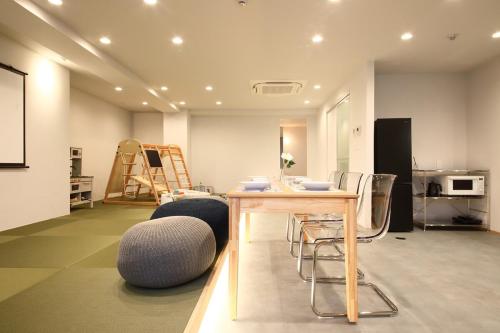 a living room with a table and some chairs at BROOMSTAY Umeda west in Osaka