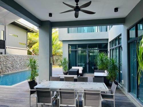 a patio with a dining table and a ceiling fan at Lavanya H Villa 12A Luxury bungalow with private swimming pool H 豪华泳池别墅 in Pantai Cenang