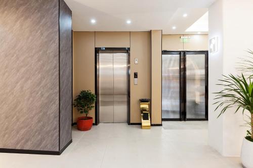 an elevator in a building with two potted plants at 尚品9号海景民宿Seaview Hotel in Xiamen