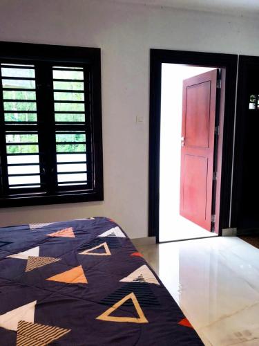 a bedroom with a bed and a window and a door at Serenity View in Batheri