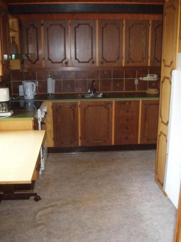 a kitchen with wooden cabinets and a sink at Strandhuset Holiday Home in Glyngøre