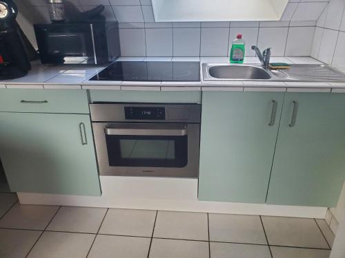 a kitchen with a sink and a stove at Idéal famille, 2 chambres au calme in Bourgueil