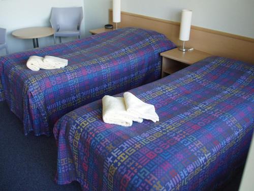 two beds in a hotel room with towels on them at Hotel Nordborg Sø in Nordborg