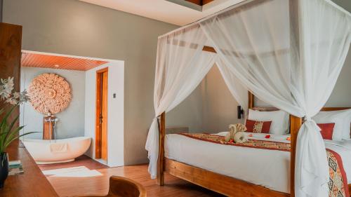 a bedroom with a bed and a tub in a room at Lovina Haven Boutique Resort in Lovina