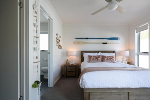 een slaapkamer met een bed en een plafondventilator bij Low Head Coastal Haven: Your Seaside Escape in Low Head