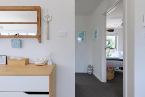 een kamer met een bureau met een spiegel en een slaapkamer bij Low Head Coastal Haven: Your Seaside Escape in Low Head