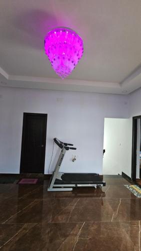 a room with a treadmill and a pink light at Shree Gowthameshwara Nilaya in Chikmagalūr