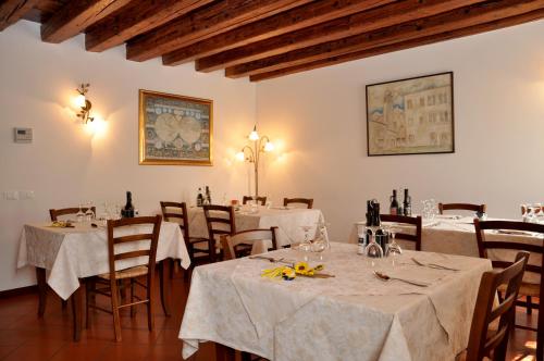 un restaurante con mesas y sillas con mantel blanco en Agriturismo Antica Pieve, en Limana