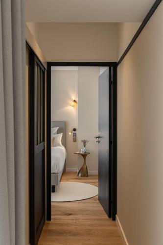 an open door to a bedroom with a bed at Hôtel de la Plage in Erquy