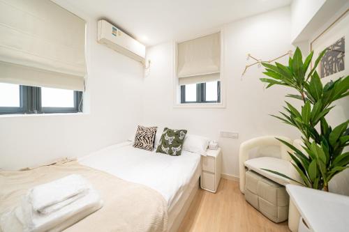 - une chambre avec deux lits et une plante dans l'établissement ChenXiang, à Shanghai