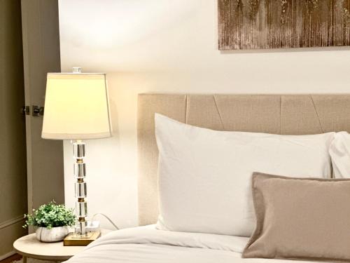 a bed with a lamp on a table next to it at Cozy 2BR Apt with Parking, Steps to Brown and RISD in Providence