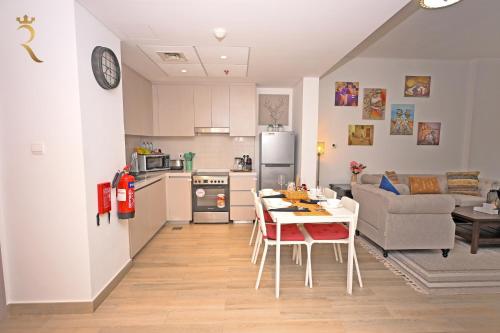 a kitchen and living room with a table and chairs at 1BR Stylish Apartment - Rossa Urban Yas Island in Abu Dhabi