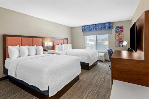 a hotel room with two beds and a flat screen tv at Hampton Inn & Suites Farmington in Farmington