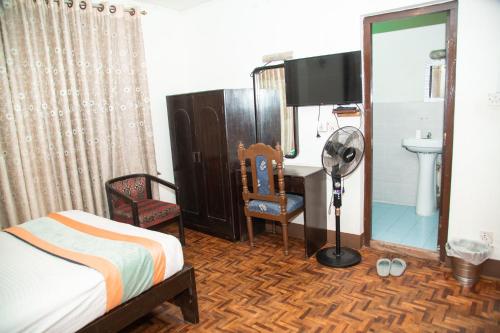 ein Schlafzimmer mit einem Bett, einem Waschbecken und einem Spiegel in der Unterkunft Holidays nomad hotel in Kathmandu
